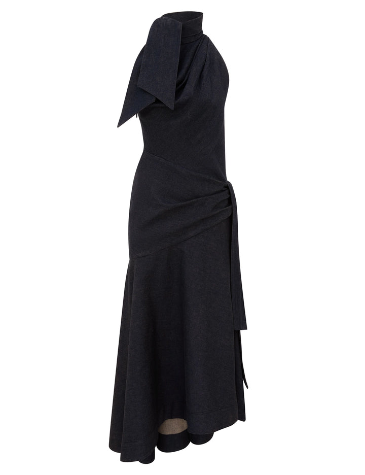 Zimmermann Valiant Draped Denim Dress in a dark washed denim with a bow-tied high neckline, draped waist with side tie and asymmetric flared hem