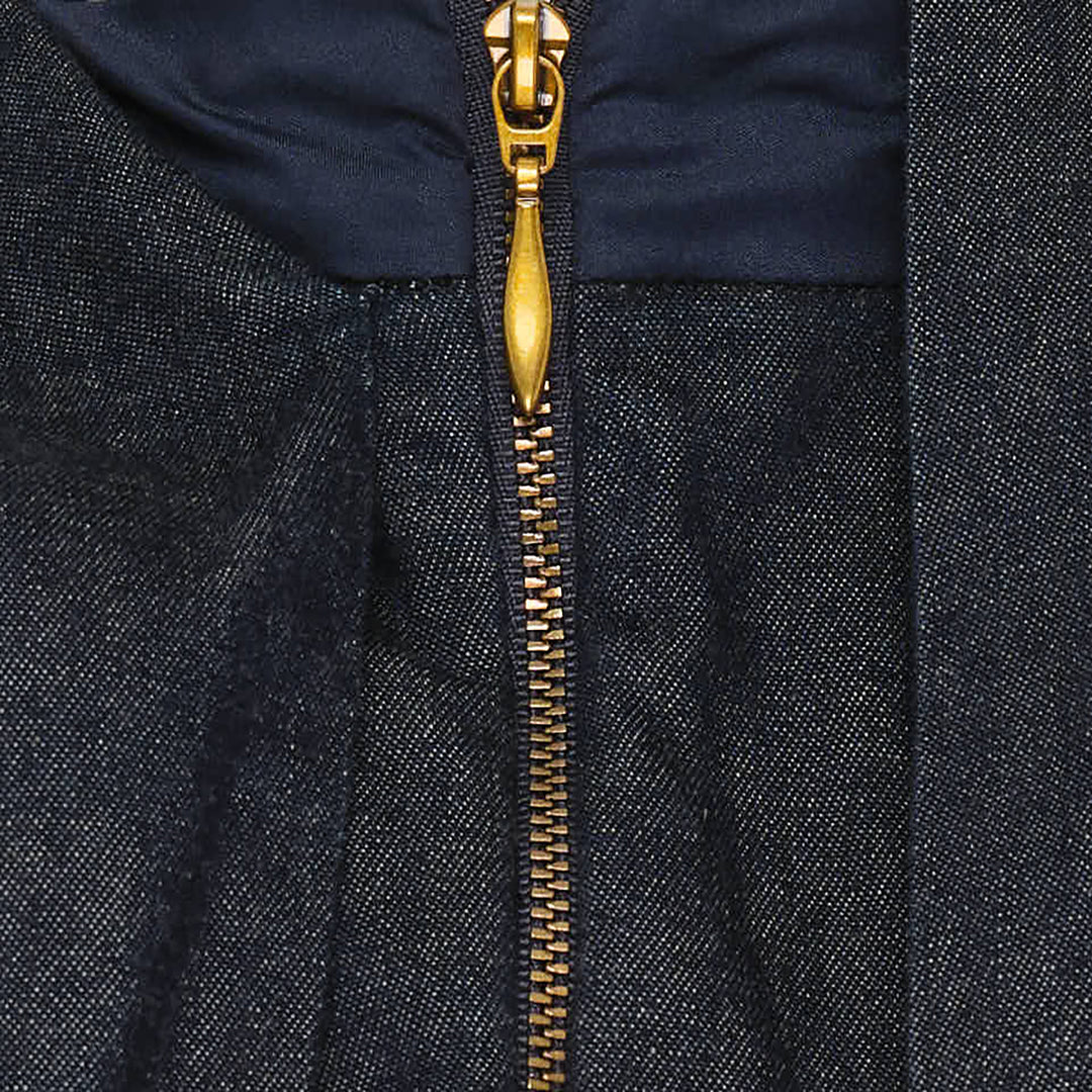 Zimmermann Draped Denim Jacket in dark indigo with cascading chest overlay, voluminous balloon sleeves, and gold-tone centre-front zip, shown on a plain white background