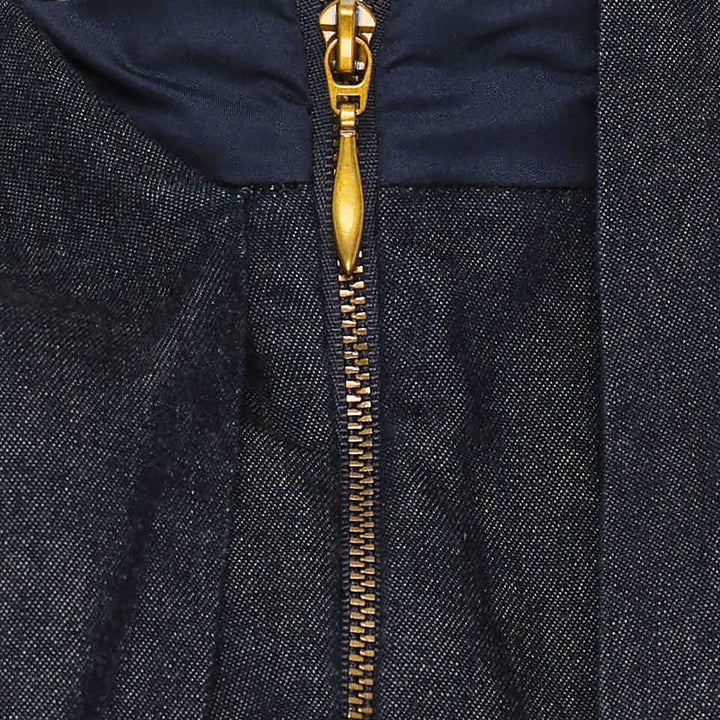 Zimmermann Draped Denim Jacket in dark indigo with cascading chest overlay, voluminous balloon sleeves, and gold-tone centre-front zip, shown on a plain white background