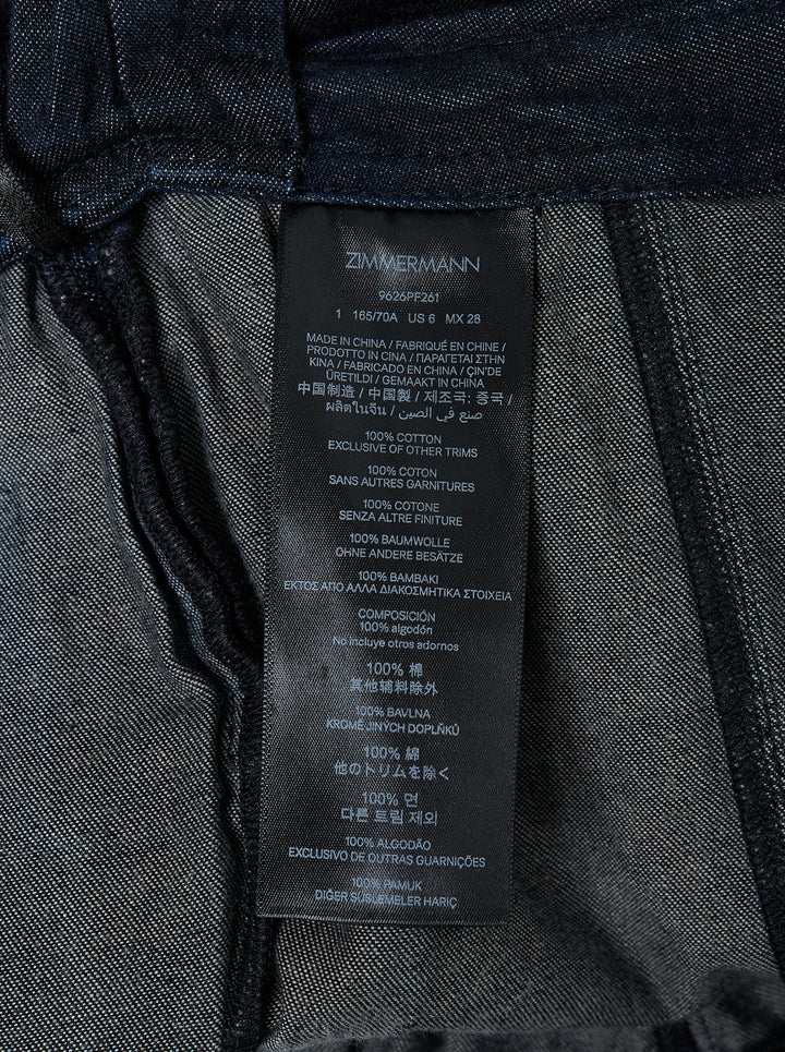 Zimmermann Draped Denim Flare Jeans in dark indigo, featuring a wide-leg silhouette with a wrap-style skirt overlay and self-tie gather detail at the hip - view 4