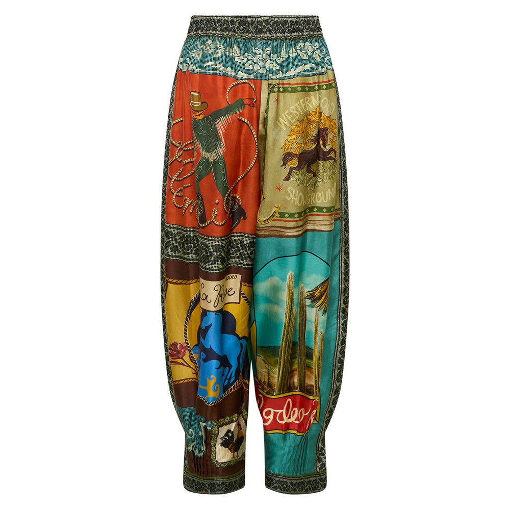 Alemais Ace Tapered Silk Pants with a vibrant rodeo-themed graphic print featuring cowboys, horses, and cacti, shown flat against a white background - view 2