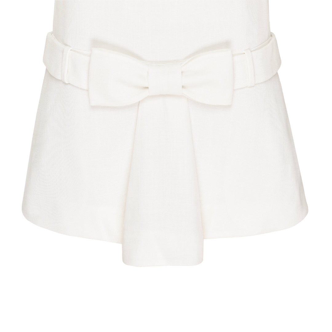 SHUSHU/TONG ivory textured short sleeve drop-waist dress with self-fabric bow detail at the waist and pleated skirt, front view