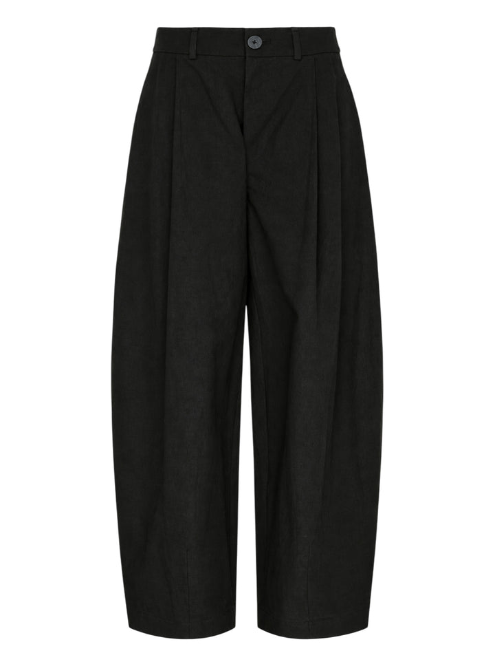 Lauren Manoogian black pleated taper trousers with a high waist and curved leg, shown from the front