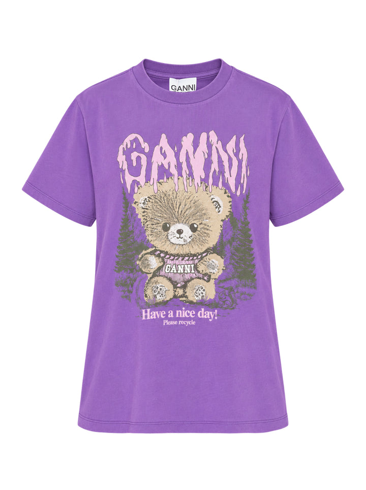 Ganni Future Heavy Relaxed Tee in purple with gothic pink dripping logo text and distressed teddy bear graphic holding a Ganni sign, set against a forest illustration, with 'Have a nice day! Please recycle' text below