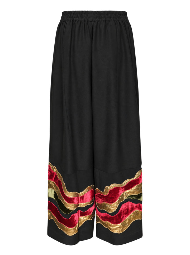 Biyan black gabardine wide leg pants with layered wavy velvet and gold metallic appliqué trim at the hem, elastic waistband, front view on white background - view 2