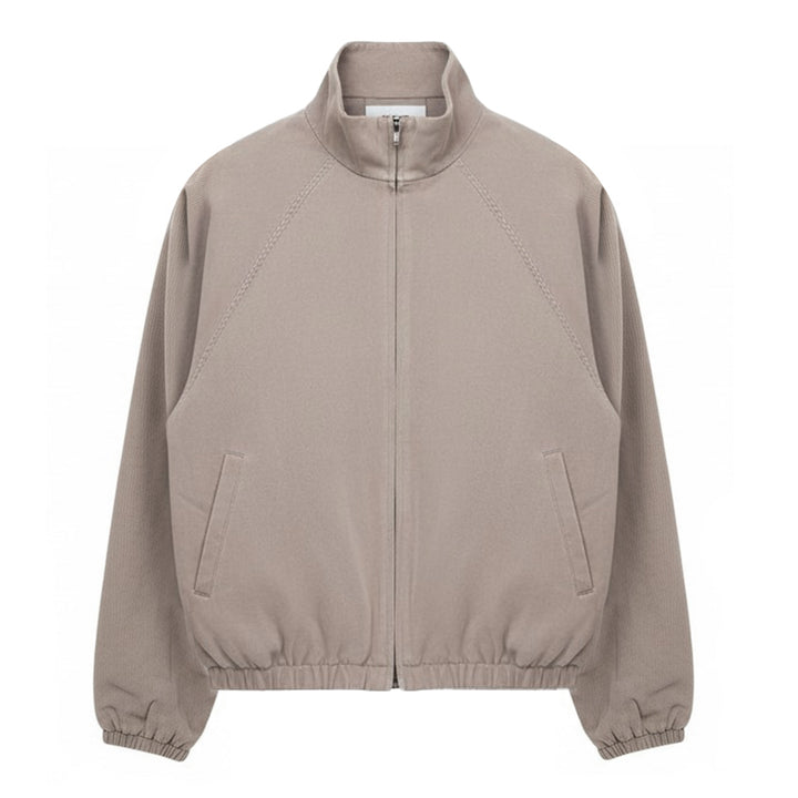 Fear of God Essentials Modern Filled Blouson Jacket in taupe, featuring a full-length zip, stand collar, raglan sleeves, and elasticated hem and cuffs, shown flat on a white background