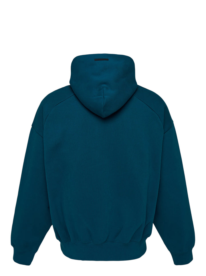Fear of God Essentials Classic Raglan Hoodie in deep teal with white script logo across the chest and tonal textured shoulder panels - view 2