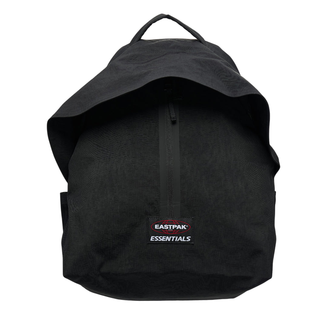 Fear of God Essentials x Eastpak black nylon backpack with roll-top flap, vertical zip pocket, and co-branded woven label on the front face