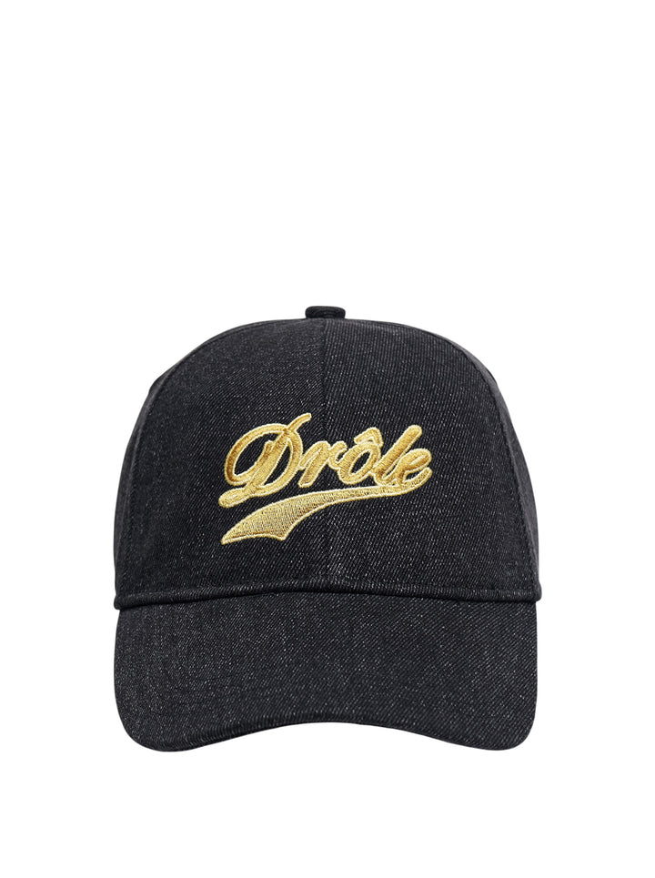 Drôle de Monsieur dark indigo denim baseball cap with gold embroidered script logo and swoosh detail on the front panel, front view