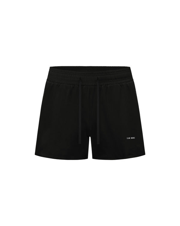 TEAM WANG design Original 1 Track Shorts in black, featuring an elasticated drawstring waistband and tonal logo print at the hip, shown flat against a white background