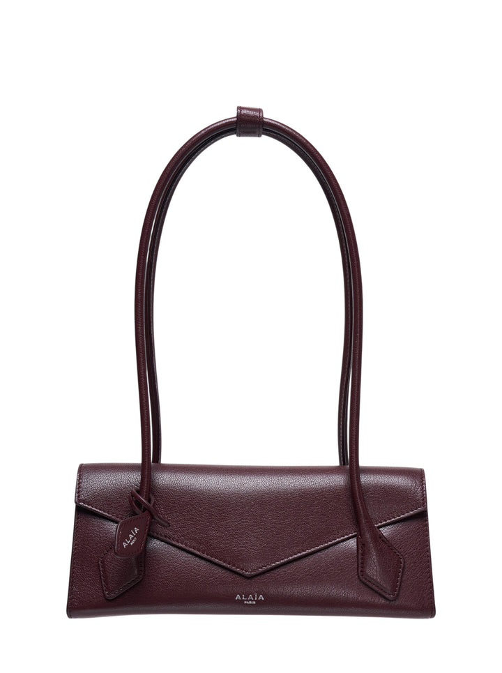Alaïa Teckel Flap Small shoulder bag in bordeaux shiny goatskin with envelope flap and twin flat handles gathered at a leather loop