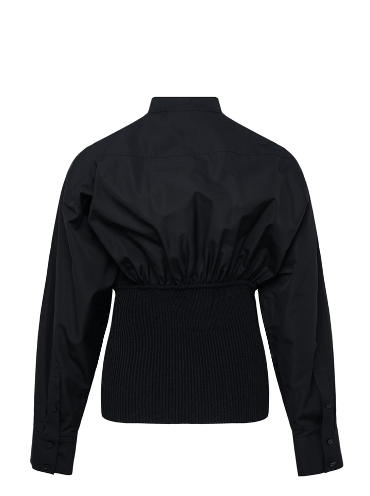 Alaïa Cinched Cotton Poplin Shirt in black, featuring a voluminous poplin upper, mandarin collar with button fastening, long sleeves, and a structured ribbed knit cinched waistband - view 2