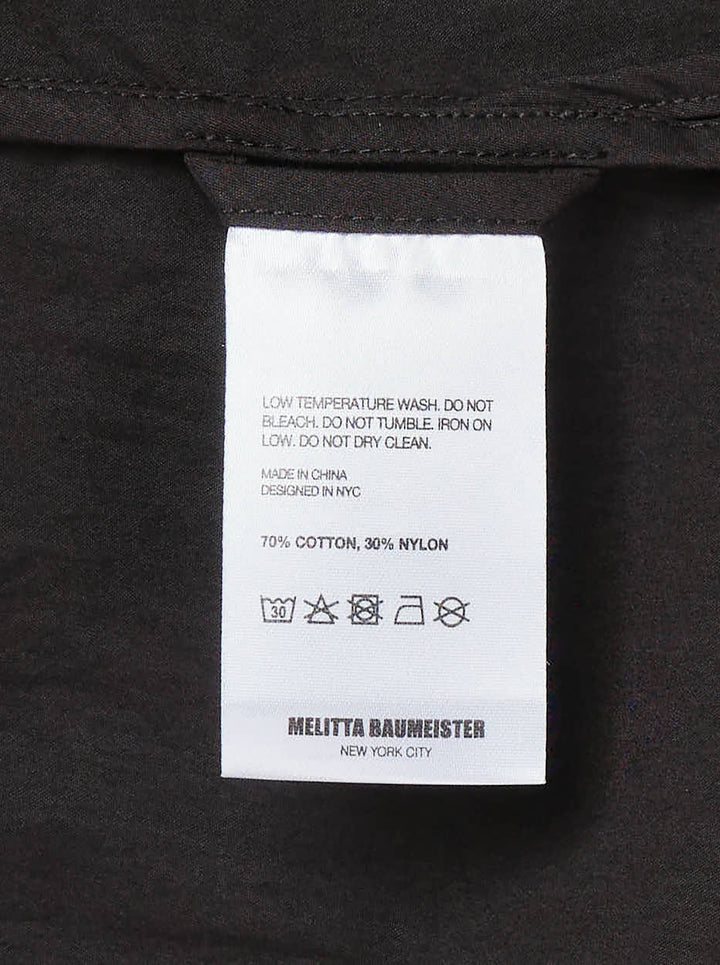 Melitta Baumeister Circle Shirt in black, featuring an asymmetric curved button placket, point collar, chest patch pocket, and structured long sleeves with wide cuffs - view 3