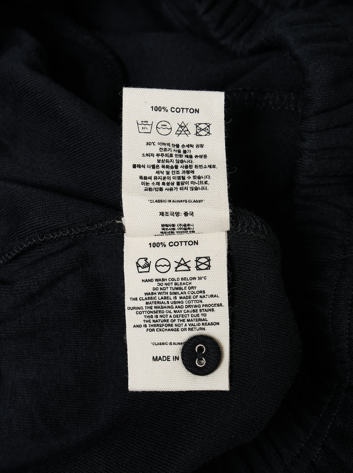 Glowny Button Fly Wide Leg Pants in black, featuring an elasticated waistband, three-button fly placket, wide-leg silhouette, and woven brand label tab at the hip - view 3