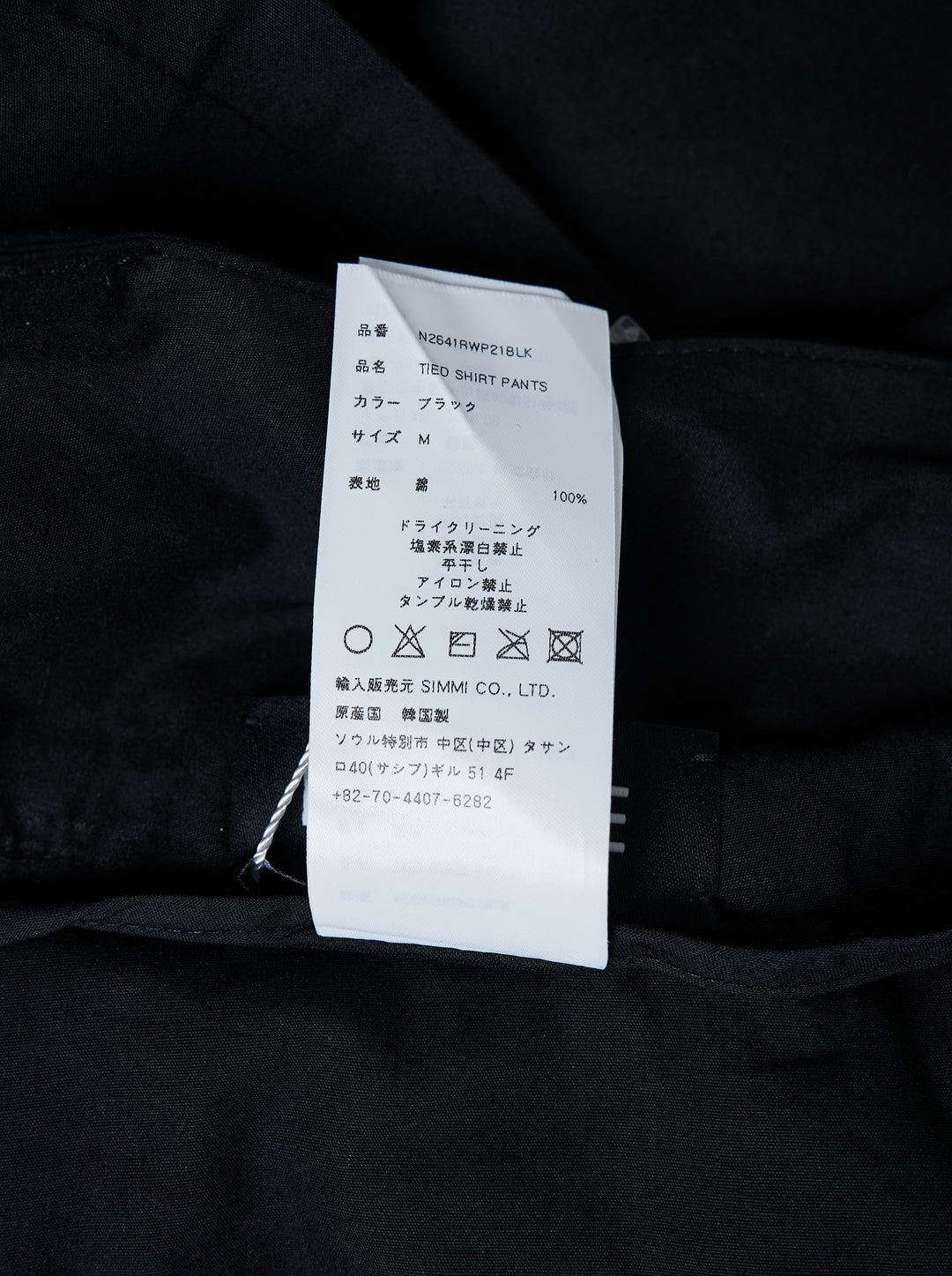 Nache Tied Shirt Pants in black, shown from the front with high waist, double snap closure and draped sleeve ties at the hips - view 4