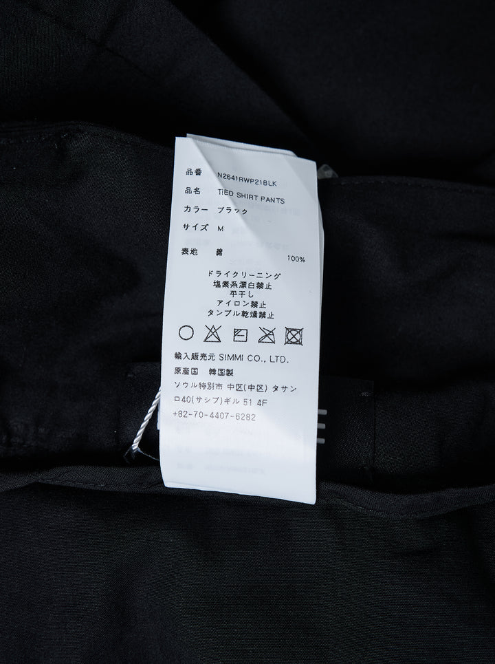 Nache Tied Shirt Pants in black, shown from the front with high waist, double snap closure and draped sleeve ties at the hips - view 4