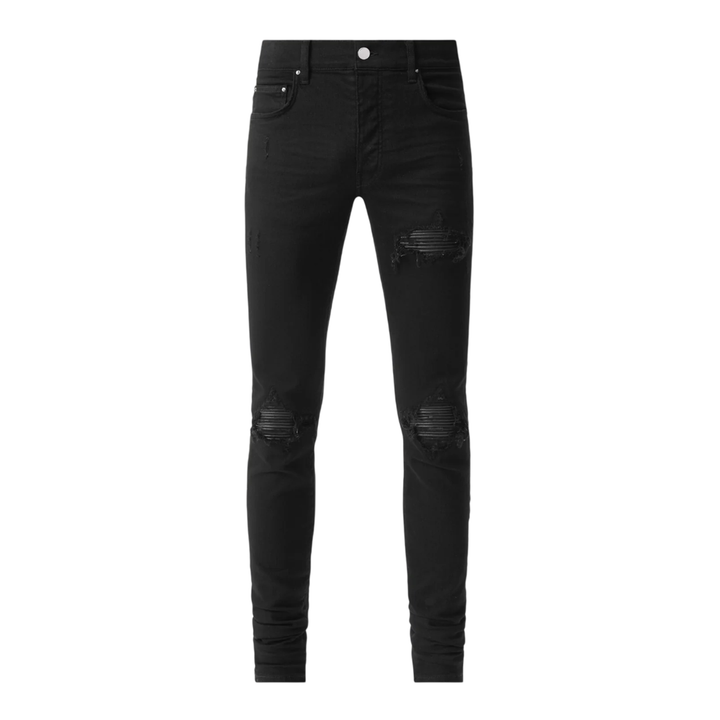 AMIRI MX1 black skinny jeans with distressed rips and ribbed leather inserts at the thigh and knee, front view on white background