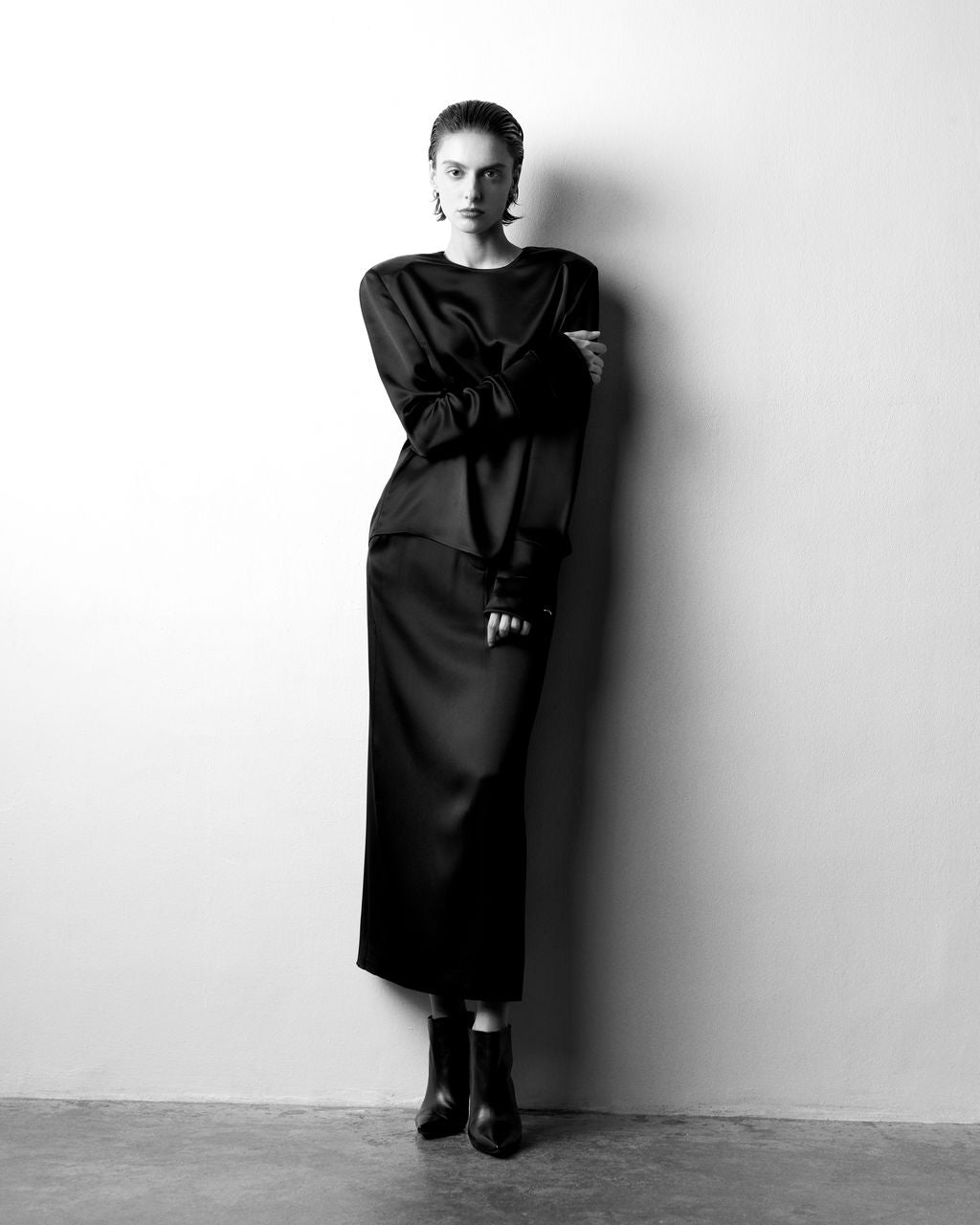 Club21 Collection Colette matte satin blouse in black, featuring long sleeves with wide flared cuffs and a crew neckline, front view on white background