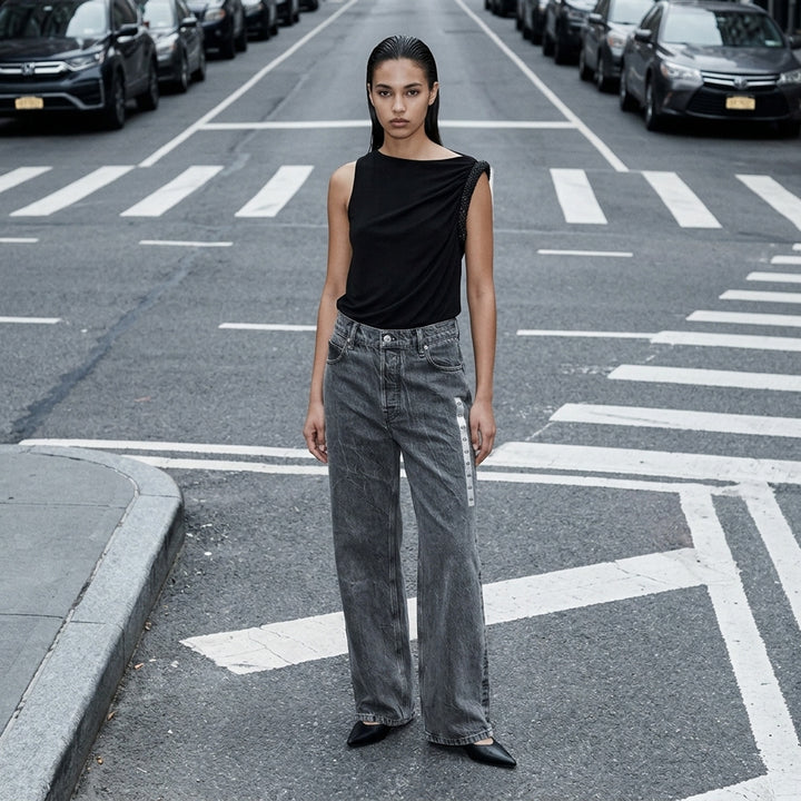 Alexander Wang unisex wide-leg jeans in washed charcoal denim with woven AW flasher label detail, front view - lifestyle