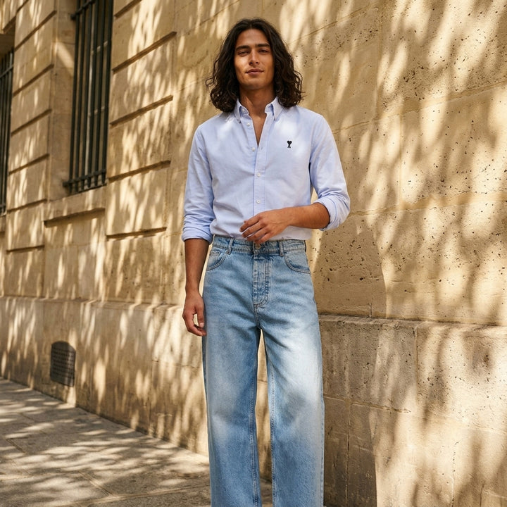 AMI Baggy Fit Jeans in light blue washed denim with wide-leg silhouette, button fly, and five-pocket design - lifestyle