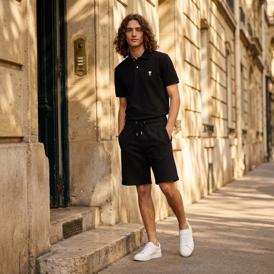 Ami Alexandre Mattiussi black piqué polo shirt with white Ami de Cœur logo embroidery on the chest and a two-button placket, front view - lifestyle