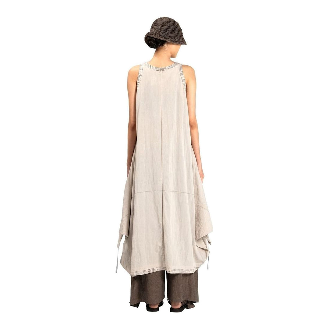 Model wearing an Anaabu black sleeveless midi dress with a voluminous A-line silhouette, asymmetric handkerchief hemline, and fine metallic stud trim at the neckline and hem - packshot