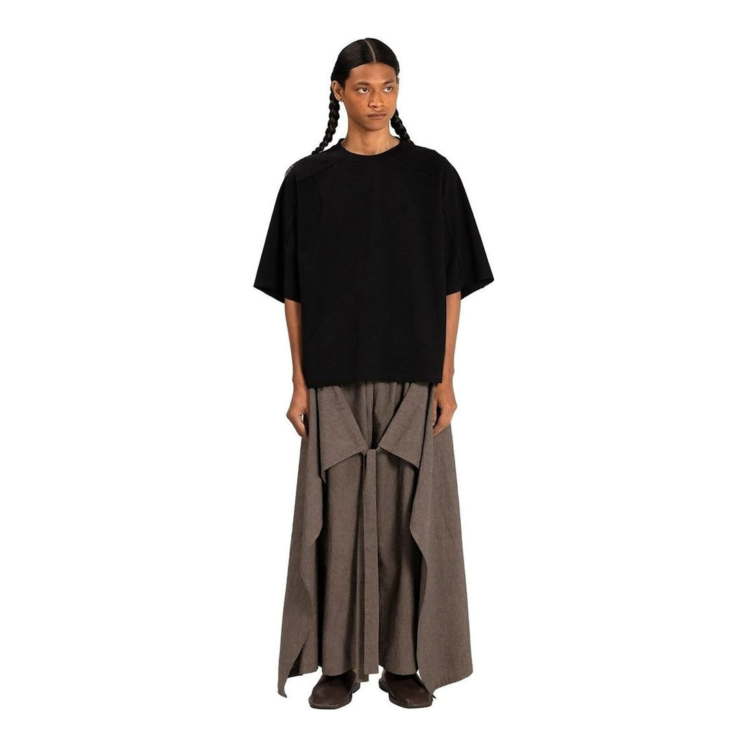 Model wearing the Anaabu Boxy Short Sleeve Tee in black — an oversized, dropped-shoulder silhouette styled over a taupe wide-leg trouser skirt - packshot