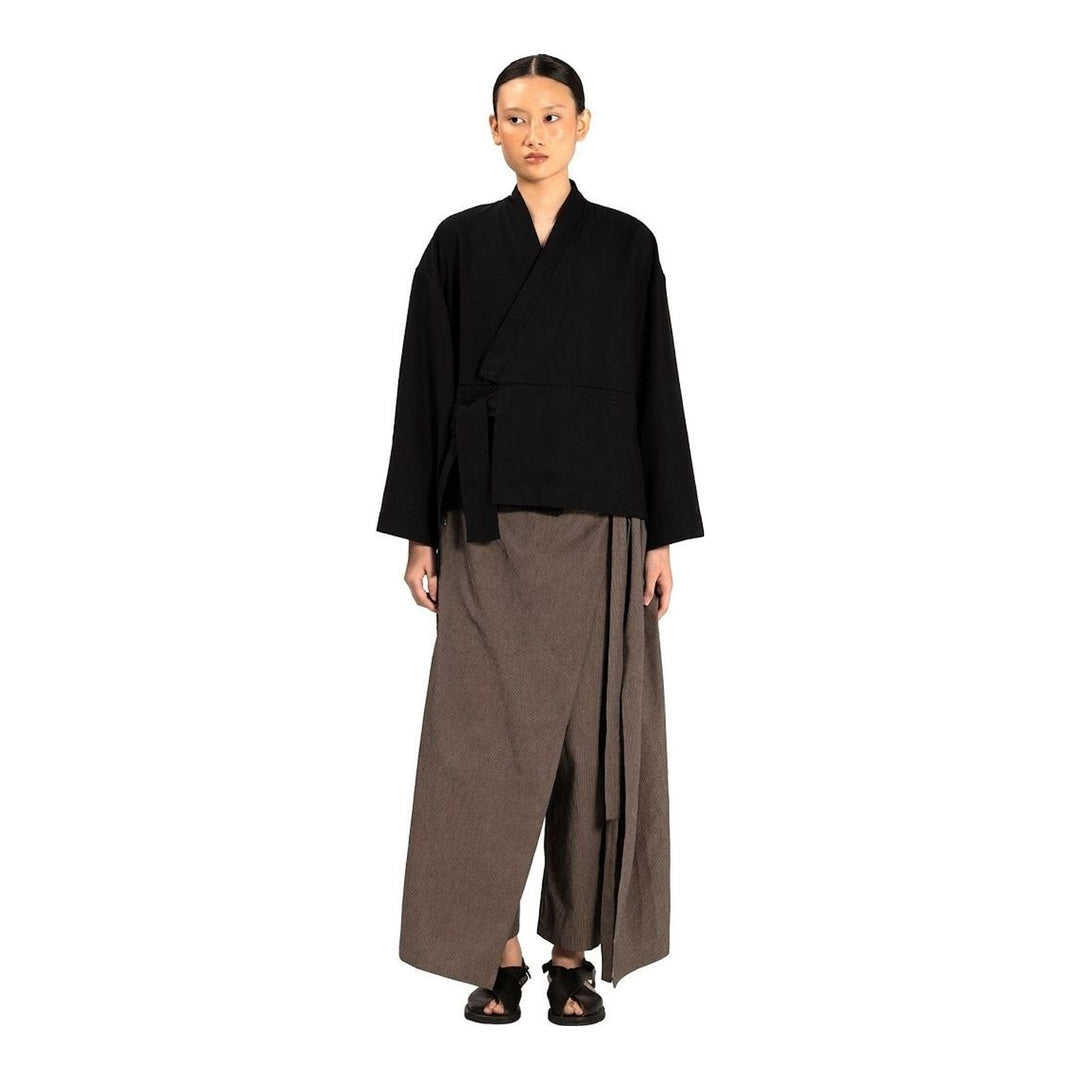 Model wearing Anaabu The Skants — black wide-leg cropped pants with large draped overlay panels featuring pinstripe and dot print, paired with a black square-neck crop top and leather sandals - packshot