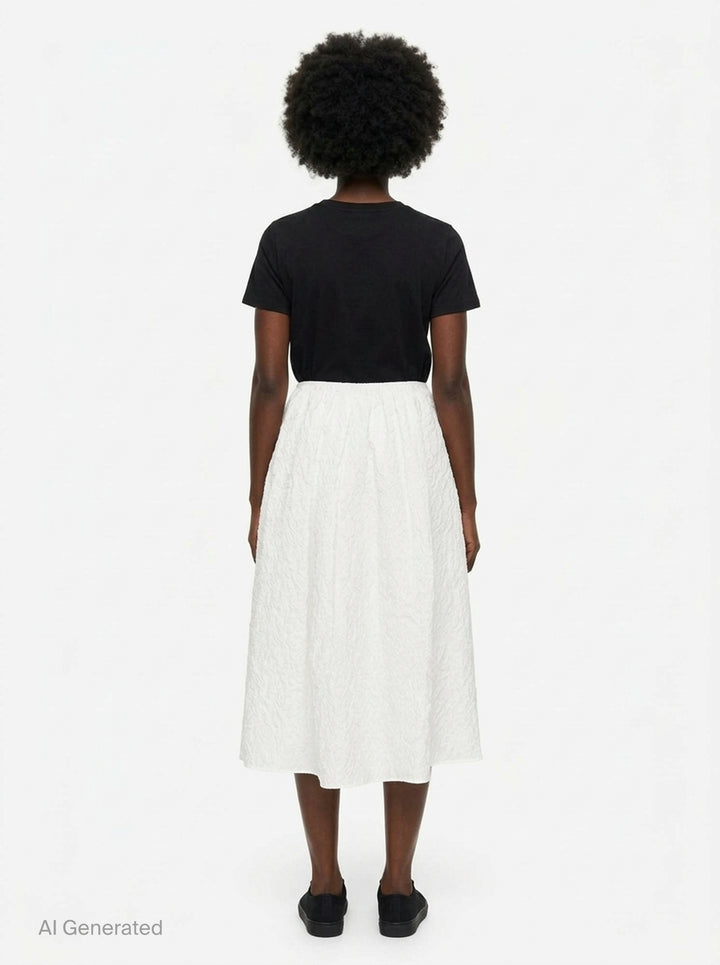 Cecilie Bahnsen Floratini Matelassé Midi Skirt in white, displayed flat, showing a voluminous A-line silhouette with an all-over raised jacquard texture and elasticated waistband - back