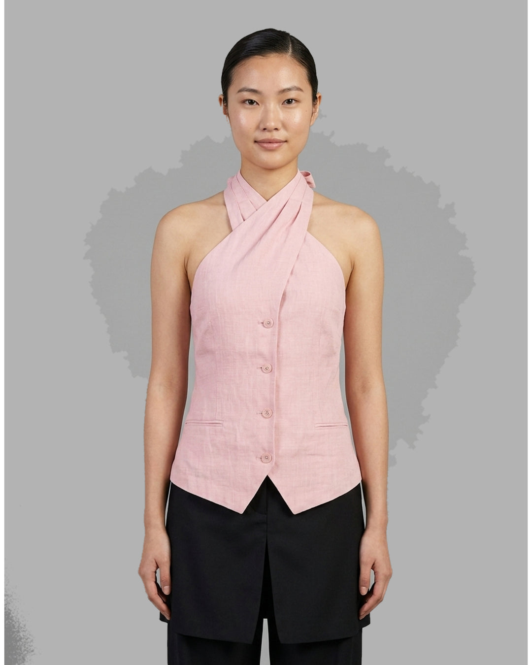 Pink hand-brushed linen Tencel halter vest with crossover neckline, back tie, button front and welt pockets - front