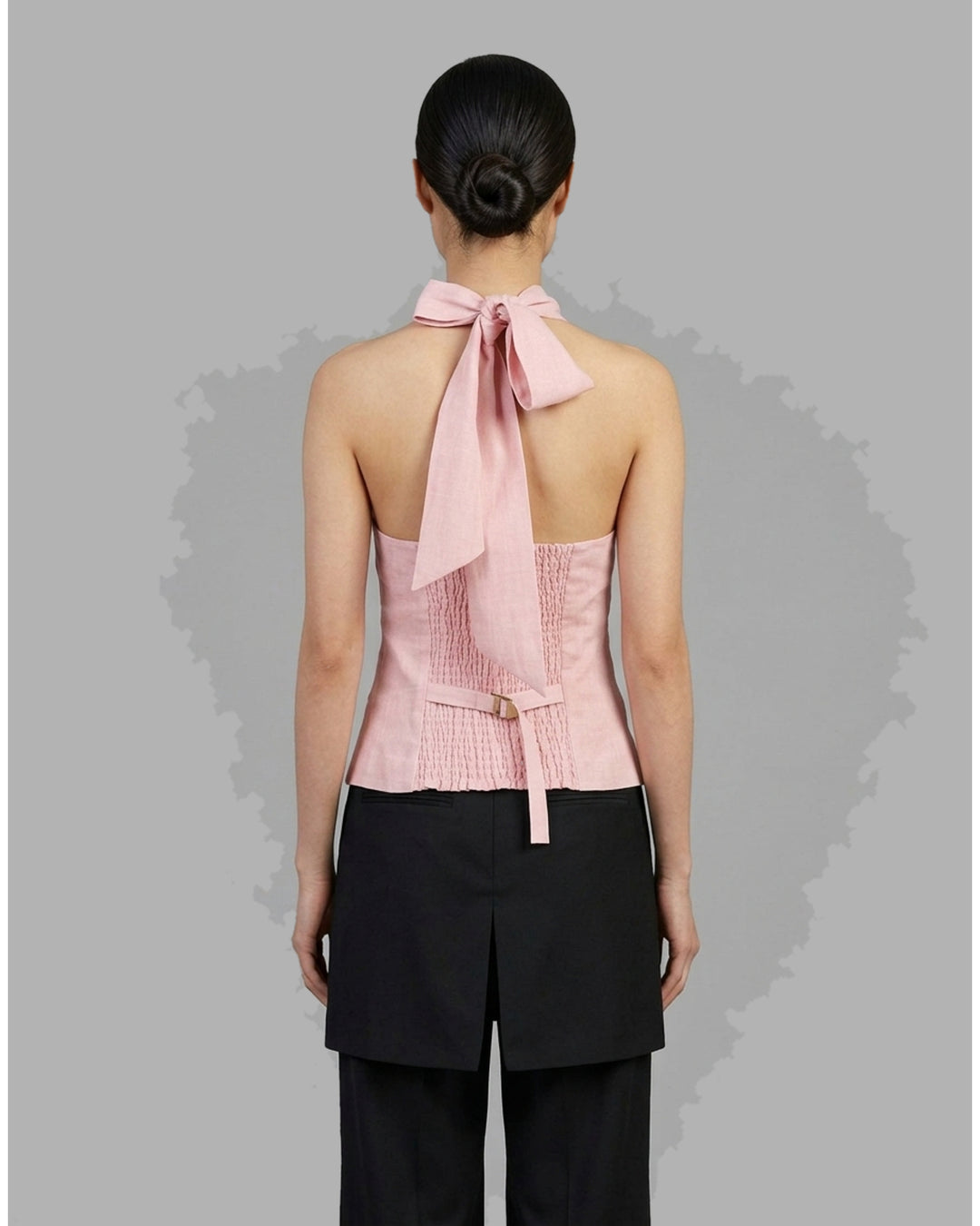 Pink hand-brushed linen Tencel halter vest with crossover neckline, back tie, button front and welt pockets - back