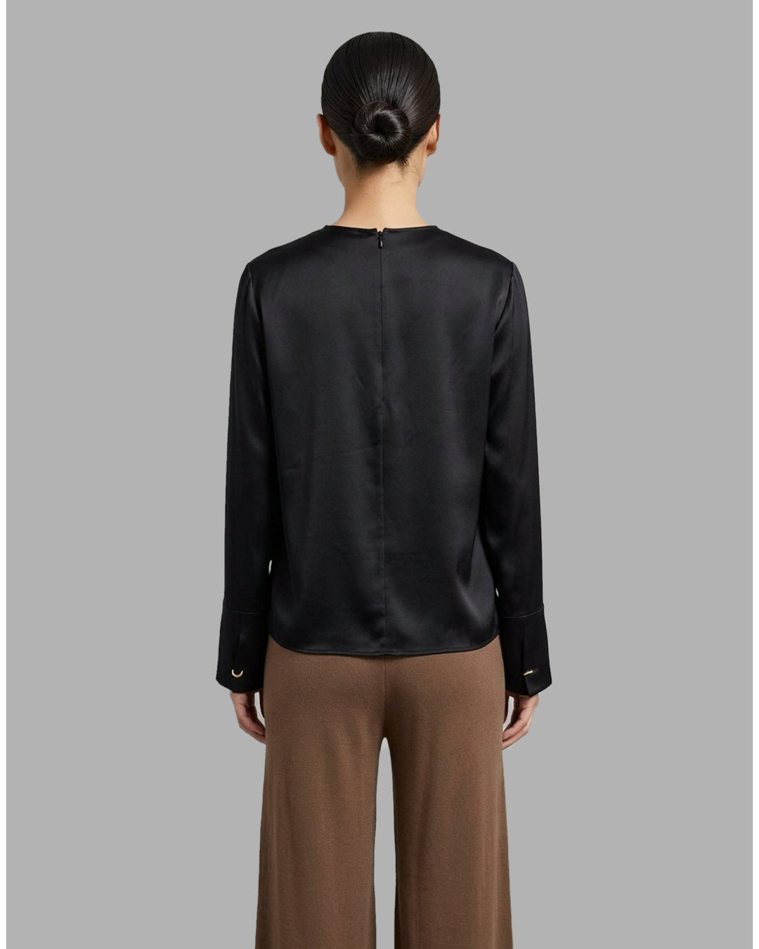 Black matte satin long-sleeve blouse with crew neckline and wide cuffs, shown flat from the front - back