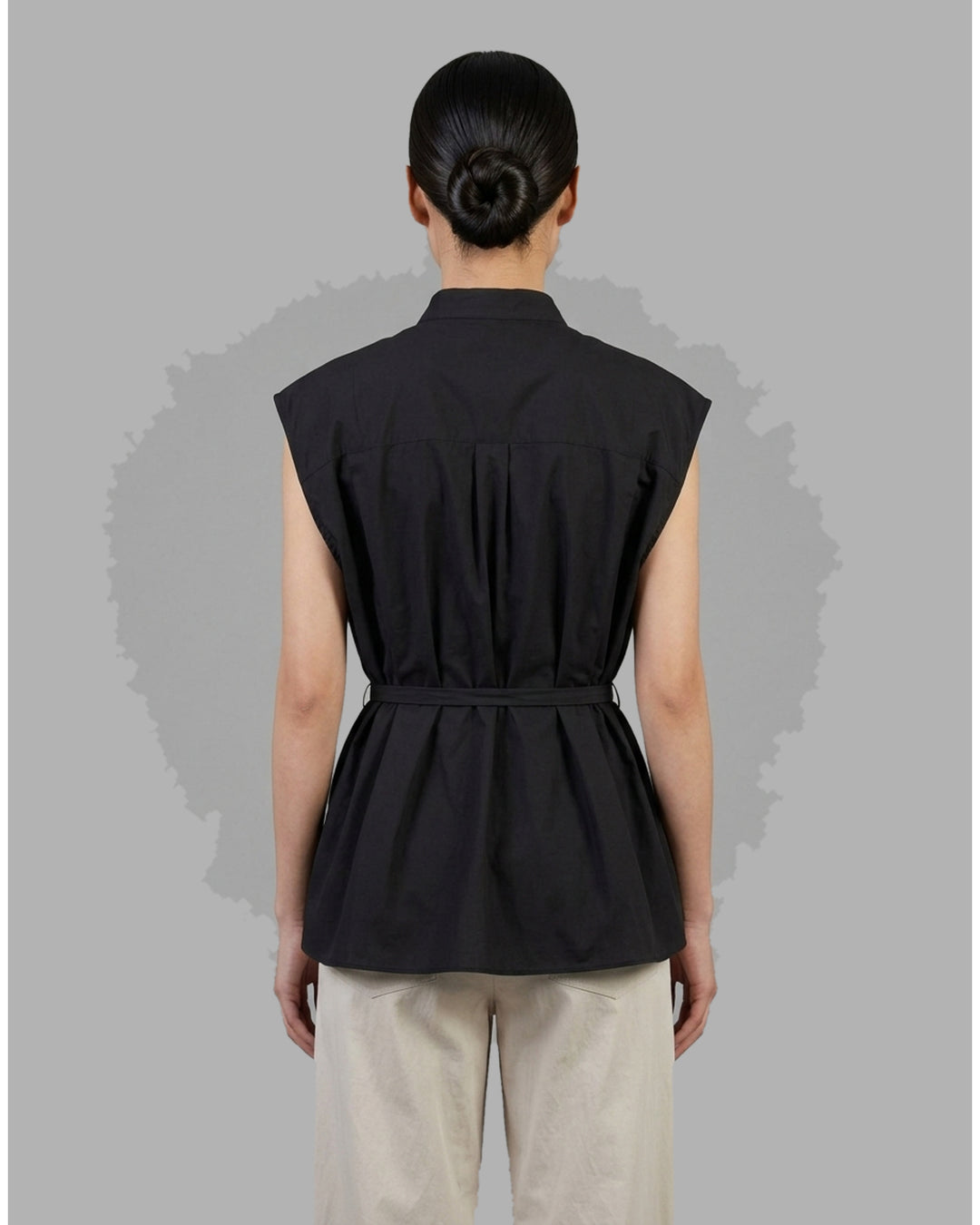 Black sleeveless cotton shirt with mandarin collar, pleated bib front and self-tie waist belt - back