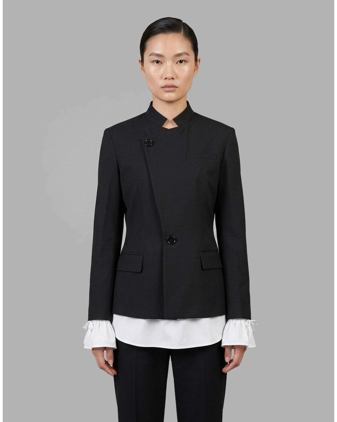 Black wool-mix tailored jacket with asymmetric button front, stand collar, welt chest pocket and flap hip pockets - front