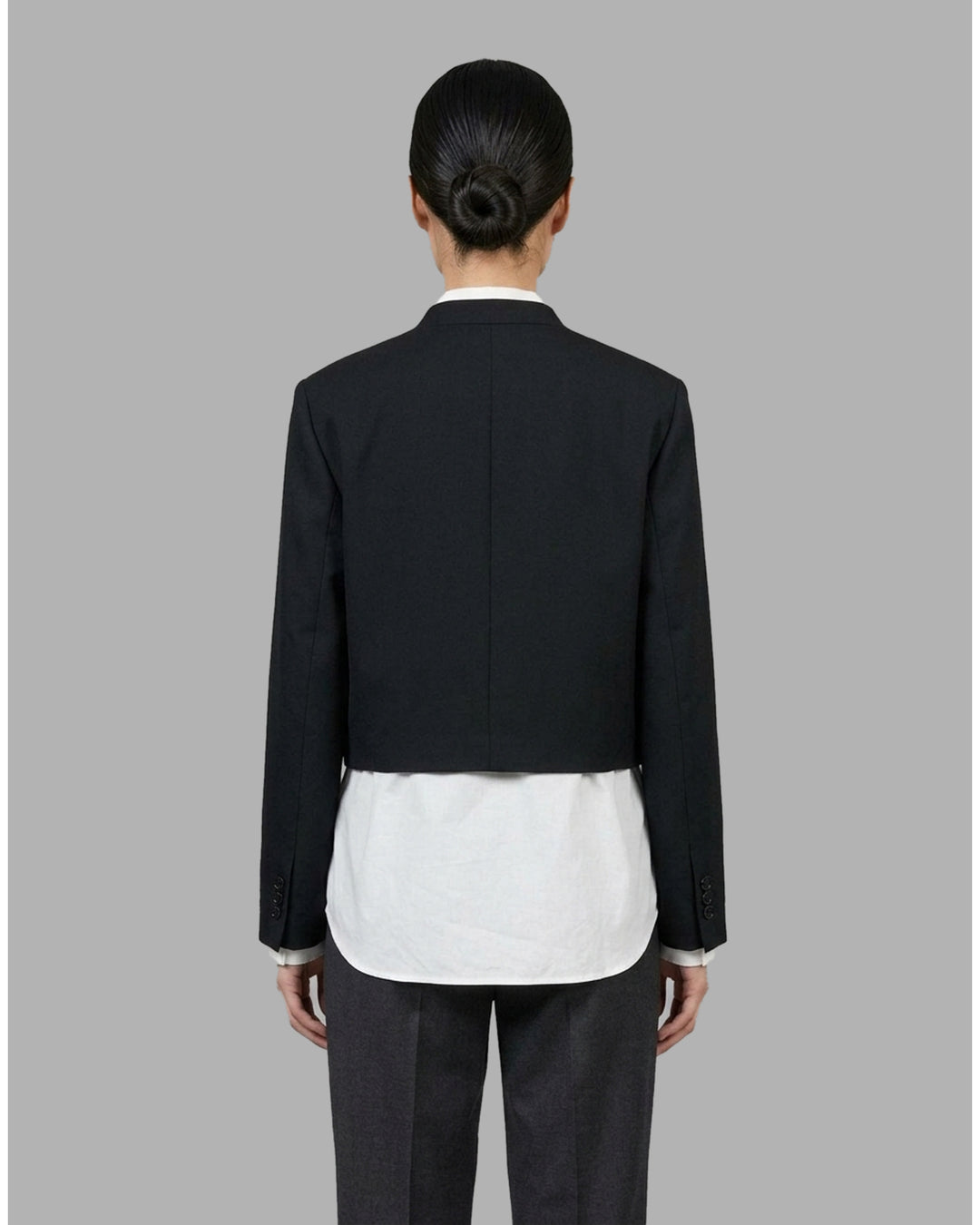Black collarless cropped jacket with asymmetric wrap front and chest flap detail by Club21 Collection - back