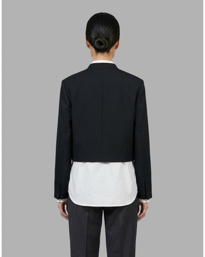 Black collarless cropped jacket with asymmetric wrap front and chest flap detail by Club21 Collection - back