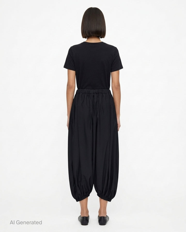 Black balloon pants with an elasticated waist and gathered hems by Comme des Garçons - back