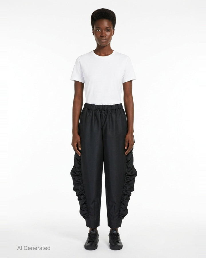 Comme des Garçons wide-leg black pants with dramatic ruched frill panels along both side seams and an elasticated waistband, displayed flat against a white background - front