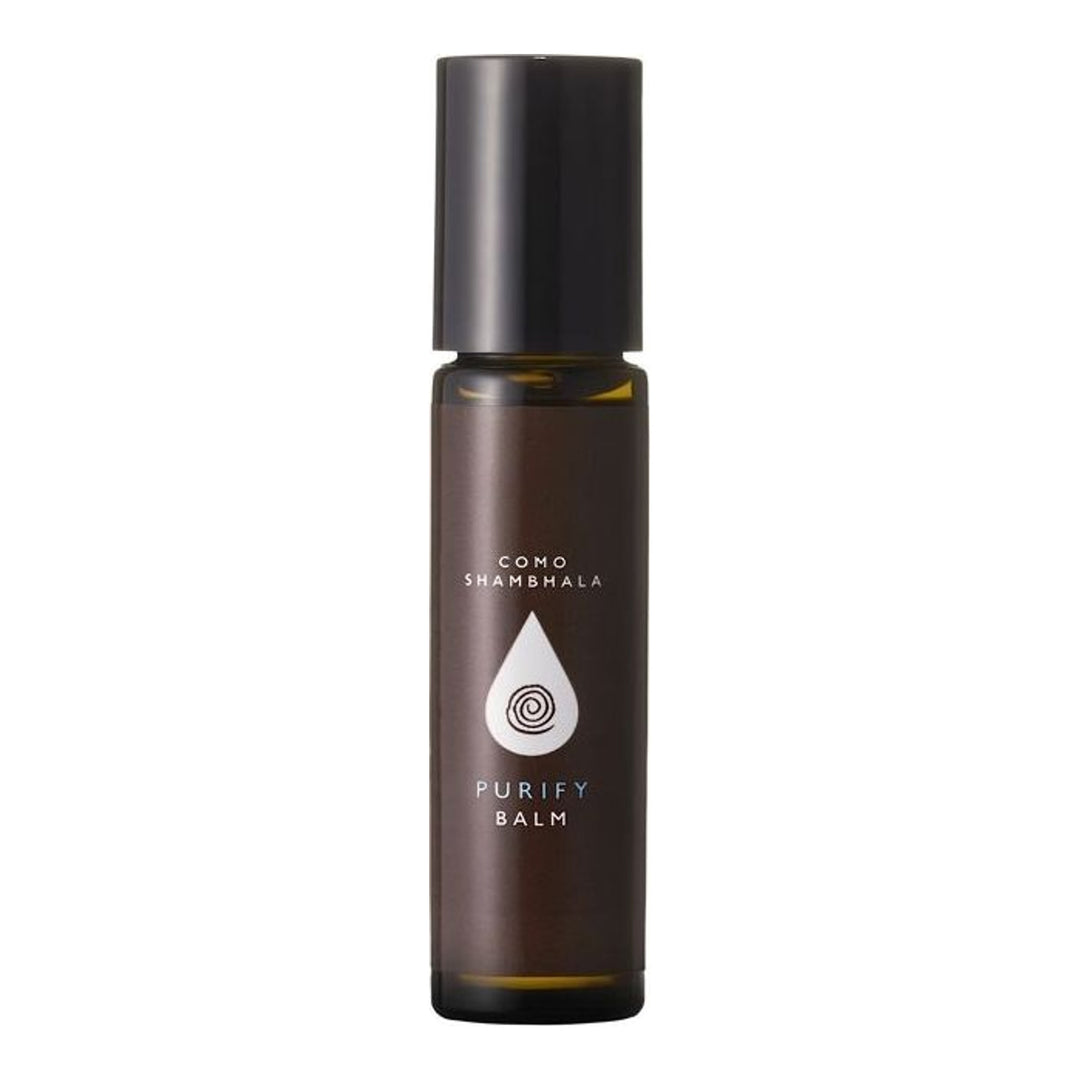 COMO Shambhala Invigorate Balm roll-on in an amber glass bottle with a black cap and white droplet emblem label - packshot