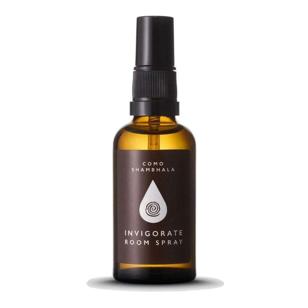 COMO Shambhala Invigorate Room Spray in an amber glass bottle with black spray pump and brown label featuring a white droplet emblem - packshot