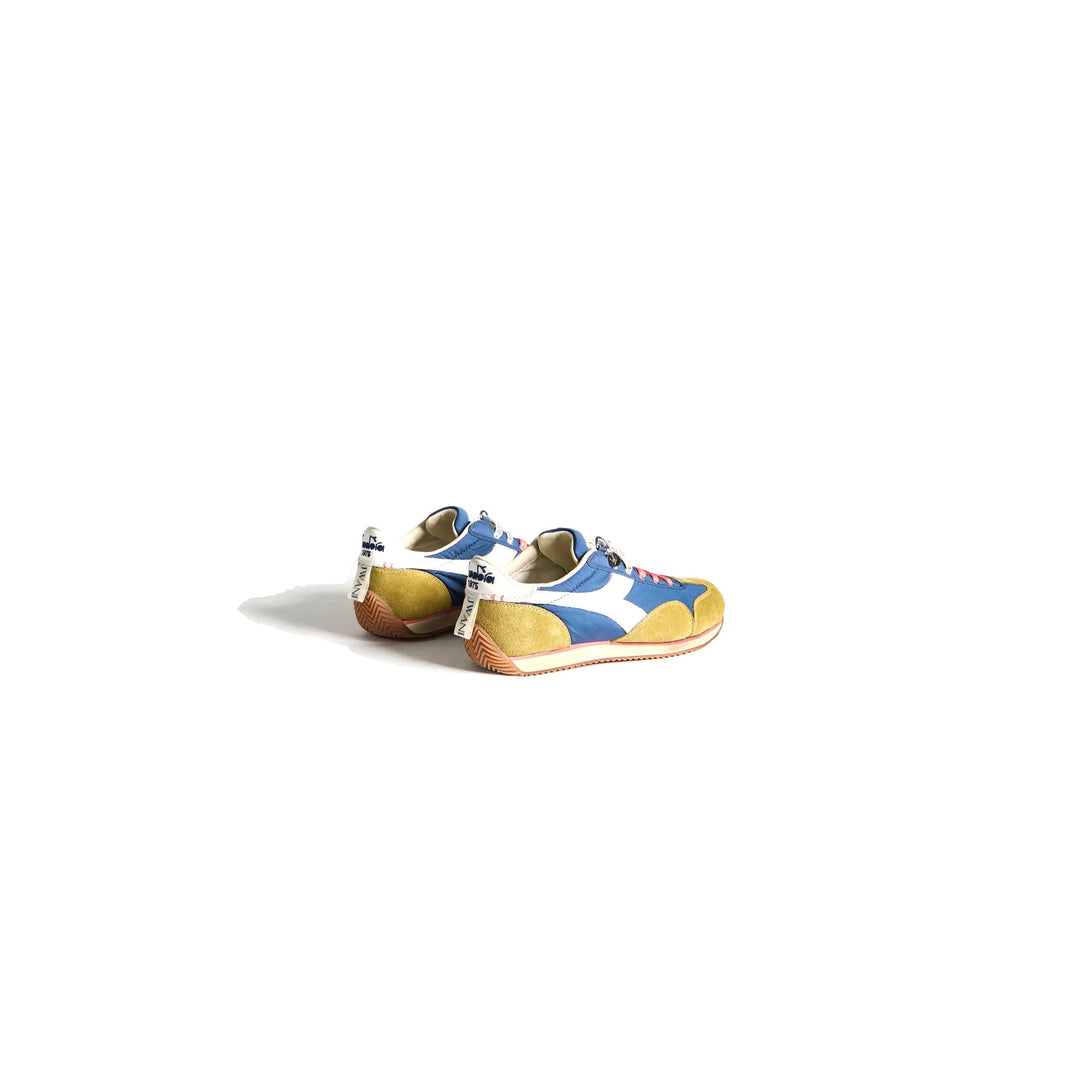 Diadora x JW Anderson retro nylon sneaker in blue with khaki suede overlays, coral laces, and a white Diadora logo stripe, set against a white background - packshot
