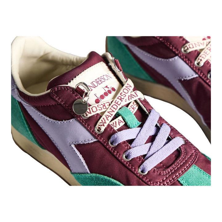 Diadora x JW Anderson retro nylon sneaker in blue with khaki suede overlays, coral laces, and a white Diadora logo stripe, set against a white background - packshot
