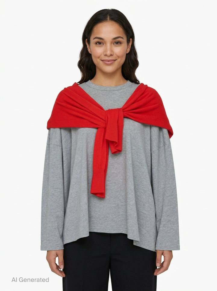 Enfold oversized grey marl long sleeve tee with attached red knitted cape draped over both shoulders and tied in a knot at the chest, styled flat on a white background - front