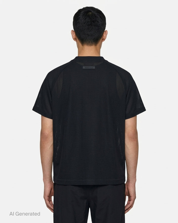 Fear of God Essentials Essential Raglan Tee in black with tonal FGE logo on the chest and ribbed crewneck, shown flat from the front - back