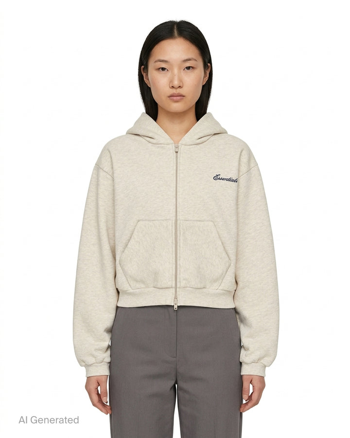 Fear of God Essentials women's modern cropped zip hoodie in washed black with embroidered script Essentials logo on the chest and front hand pockets - front