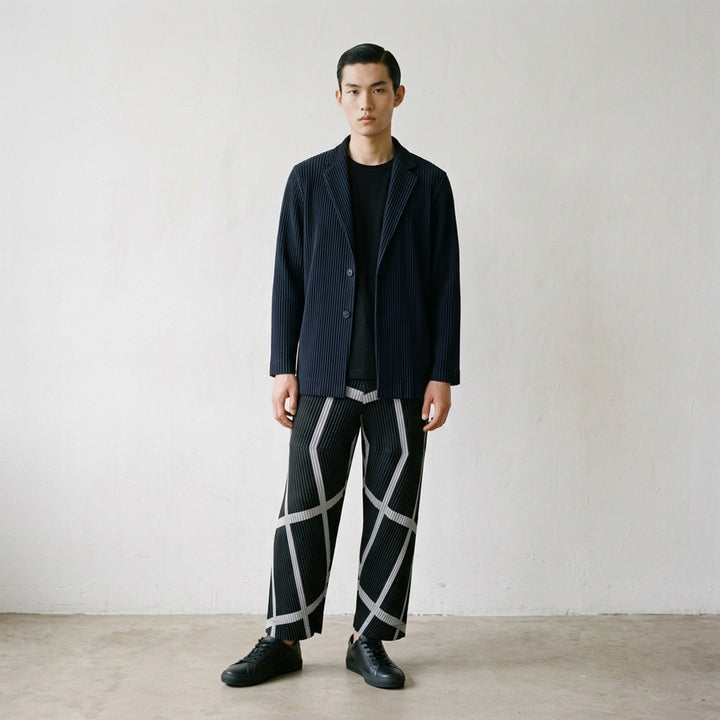 Homme Plissé Issey Miyake Basic Two Button Jacket in black with signature all-over vertical pleating and notched lapel, front view - lifestyle