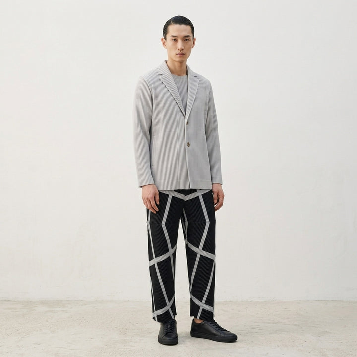 Homme Plissé Issey Miyake Basic Two Button Jacket in black with signature all-over vertical pleating and notched lapel, front view - lifestyle