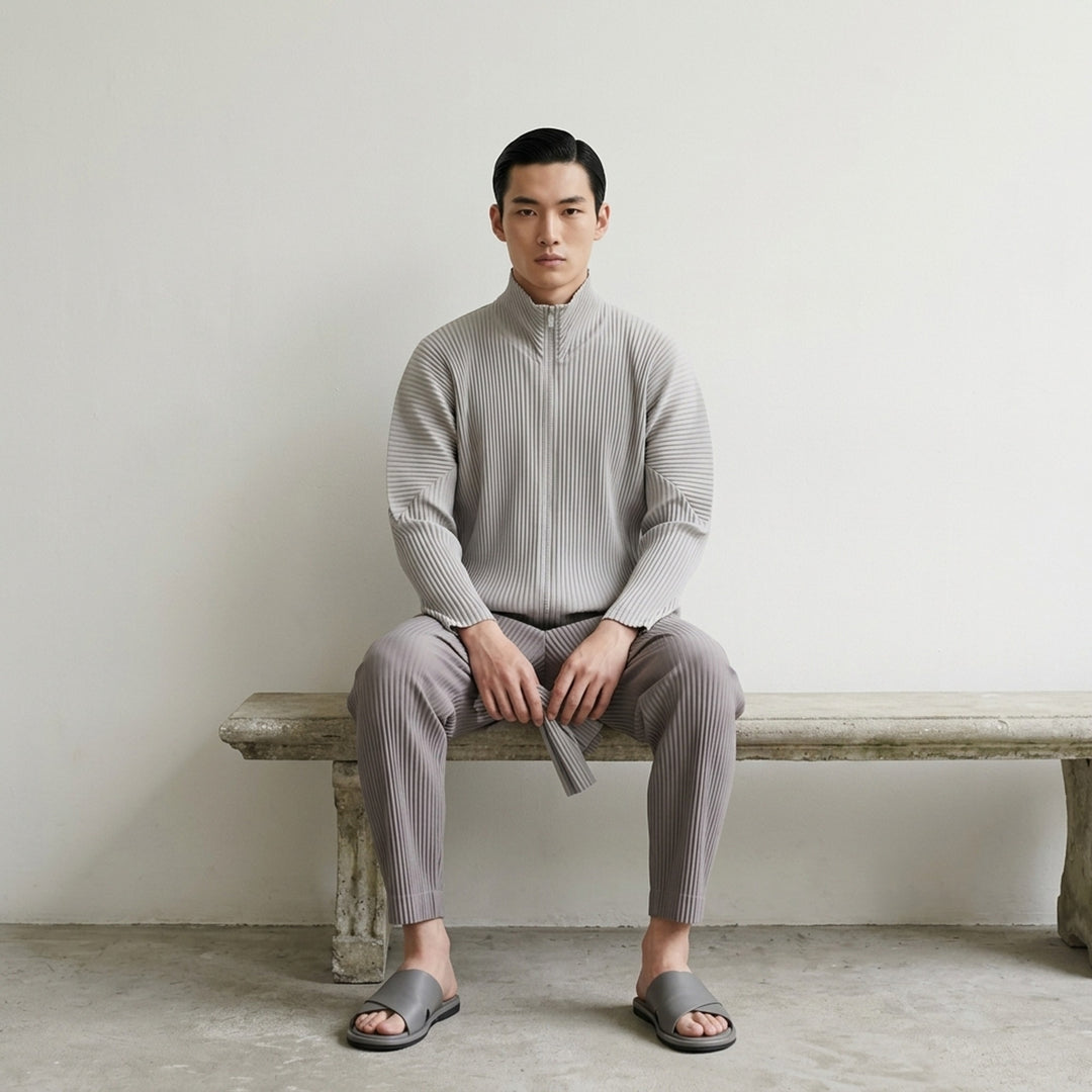 Homme Plissé Issey Miyake Basics Zip-Up Cardigan in light grey with all-over steam pleating, funnel neck, and full-length tonal zip, displayed flat on white background - lifestyle