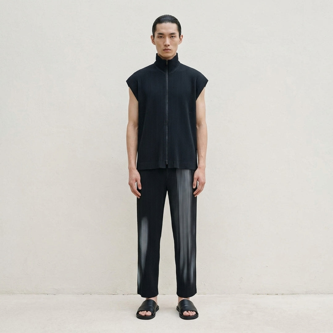 Homme Plissé Issey Miyake In The Shadow pleated pants in black with a blurred grey-blue vertical stripe print, shown from the front - lifestyle