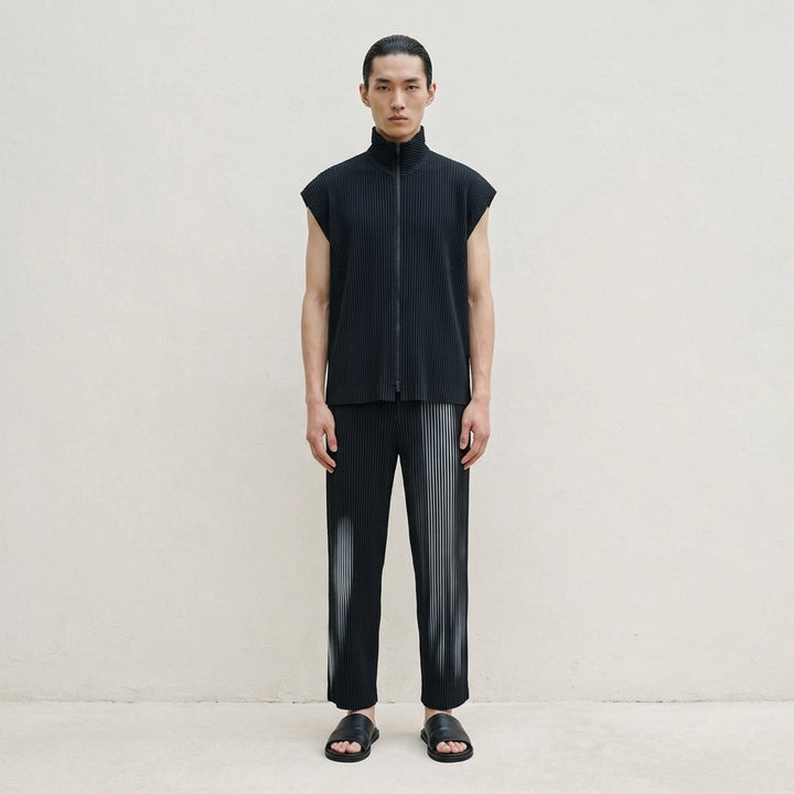 Homme Plissé Issey Miyake In The Shadow pleated pants in black with a blurred grey-blue vertical stripe print, shown from the front - lifestyle